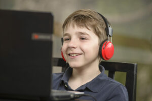 Boy with headphones watching a video on a laptop